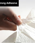 Hand demonstrating the strong adhesive feature of Self Sealing Bubble Mailers 9.5 By 13.5 Inches 25 Pack Poly Padded Shipping Envelopes.