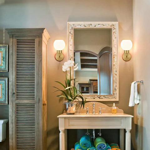 Gold Modern Bath Wall Sconce With Opal Glass Globe Vanity Lights Set Of 2 in cozy bathroom above a linen cabinet and sink.
