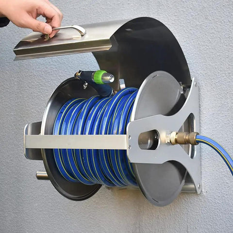 Stainless Steel Garden Hose Reel With Durable Protective Cover And Smooth Metal Crank For 50 Foot Hoses mounted on wall with blue hose.