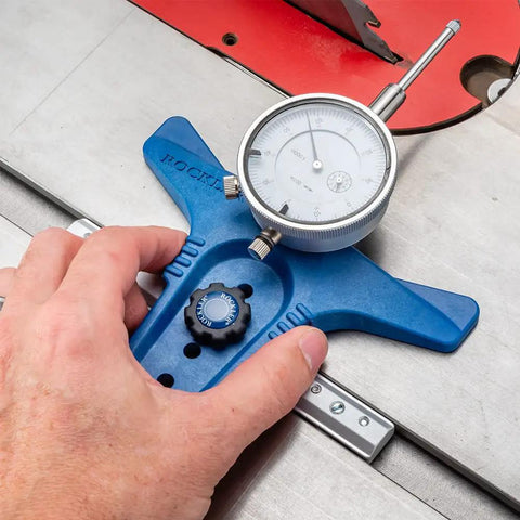 Hand adjusting Table Saw Alignment Gauge With Precision Dial Indicator For Perfect Parallel Cuts on a blue aluminum miter bar.
