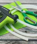 Full Size Clear Hot Glue Stick Roll, 5 Feet Long and 0.43 Inch Diameter, shown with green scissors on wooden surface