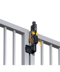Close-up of a classic black vertical pull safety gate latch with alarm on a fence, ensuring security for kids and pets.