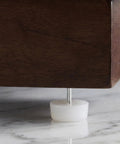 Close-up of a 100-Pack White Nail-On Furniture Glides for Sofas and Chairs, 0.94 Inch Round Sliders, on hardwood floor
