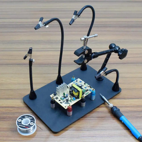 Magnetic Helping Hands Soldering Station with Heavy Duty Base and Four Flexible Arms holding PCB for electronics repair.