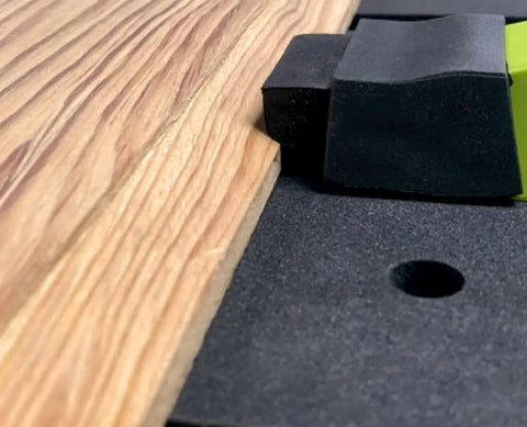 Close-up of Low Profile Clamp Kit for CNC Machines MFT Tables with clamp and fence on wood surface for secure workholding.