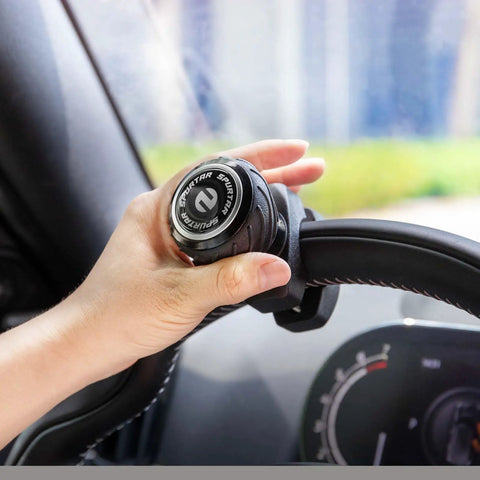 Hand using Universal Steering Wheel Knob Power Handle Spinner for cars, trucks, forklifts, tractors, boats, and golf carts, non-slip grip