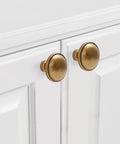 Front view of 10 Pack Antique Brass Cabinet Knobs for kitchen cabinets with 32mm diameter zinc alloy material, installed on white doors.