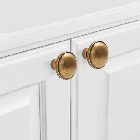Front view of 10 Pack Antique Brass Cabinet Knobs for kitchen cabinets with 32mm diameter zinc alloy material, installed on white doors.