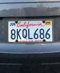 Car with license plate mounted using Stainless Steel License Plate Bracket Kit For Front Bumper Built To Last Universal Car Tag Mount With Screw Caps And Zip Ties Includes Adapter For SUV RV Truck Black.