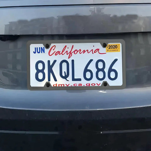 Car with license plate mounted using Stainless Steel License Plate Bracket Kit For Front Bumper Built To Last Universal Car Tag Mount With Screw Caps And Zip Ties Includes Adapter For SUV RV Truck Black.