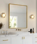 Alabaster Wall Sconce, 7.5" Natural Marble Wall Lamp with Milk Glass Shade beside a round mirror in a modern bathroom.