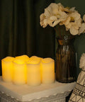 Flickering Flameless LED Candles Real Wax Pillar Set Of 6 with vase of flowers, battery operated, 5 by 3 inches, cozy living room setting