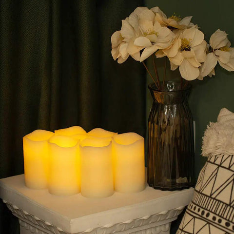 Flickering Flameless LED Candles Real Wax Pillar Set Of 6 with vase of flowers, battery operated, 5 by 3 inches, cozy living room setting