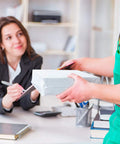 Person in green apron hands over package in 10x13 White Poly Mailers 200 Pack Self Sealing Shipping Envelopes to smiling woman