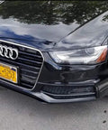 Front view of a black car with a mounted license plate, featuring a Two Pack Slim Stainless Steel License Plate Frames With Mirror Polish Finish, 4 Hole Design That Wont Block State Tags, Includes Chrome Screw Caps, Rust Resistant, Built Tough For Cars And Trucks.