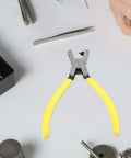 Single Hole Punch Handheld Metal Hole Puncher for paper sheets, yellow ergonomic grip, surrounded by craft tools for DIY projects