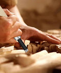 Close-up of a hand using a Pro Grade Ten Piece Wood Carving Chisel Set Forged From Heat Treated Chrome Vanadium Steel.