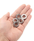 Hand holding 12 Piece Stainless Steel Spacer Set 12mm Bore 20mm OD 6mm Length For M12 Screws Bolts And Rods Plain Finish 304 Stainless Steel Construction Heavy Duty Corrosion Resistant Round Metal Spacers