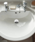 Bathtub Stopper Plug for 42-44mm Holes, Silicone Steel White installed in a white sink with chrome faucets and soap.