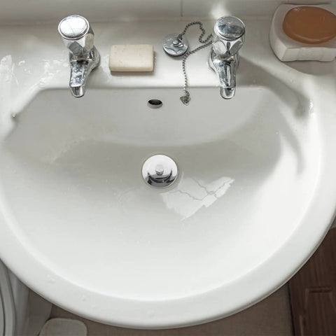 Bathtub Stopper Plug for 42-44mm Holes, Silicone Steel White installed in a white sink with chrome faucets and soap.