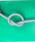 Person holding extended length PVC nylon steam hose tied in a knot showing durability for high temperature garment steamers.