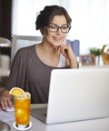 Woman using laptop with drink on 20 Pack Sublimation Coaster Blanks Set With Square And Round Cup Mats For DIY Heat Transfer Projects Perfect For Craft Folks