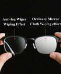 Front view of black-frame glasses held apart to compare anti-fog wipe on left lens vs ordinary mirror cloth on right.