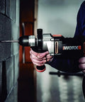 Knockout Impact Drill Packing 810 Watts And A Beefy 13 Mm Chuck Featuring Variable Speed Control in use on masonry wall.
