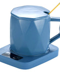One Tap Control Keeps Your Morning Brew Piping Hot At 55 Degrees. Blue ceramic coffee cup warmer with heating pad and angled mug.