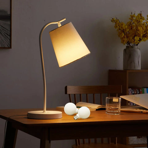 Dimmable Flick Free LED Globe Bulbs G25 G80 Matte Porcelain White on desk with table lamp in cozy home setting