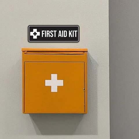 Durable Navy Blue And White First Aid Kit Sign on wall above orange first aid box