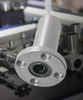 2 Pack LMF12LUU Round Flange Linear Ball Bearing With 12Mm Bore And 21Mm OD Heavy SA52100 Carbon Steel in a workshop setting.