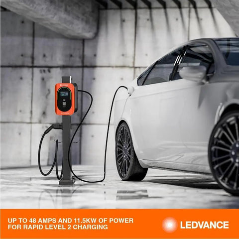 Top Tier Level Two Electric Vehicle Charger Delivers Hella Fast 48 Amp 11point5 Kilowatt Power With A Slick Screen Interface J1772 Connector And Long 25 Foot Heavy Duty Cable Built For Commercial Parking Lots Or Home Garages, mounted next to a vehicle in a garage.