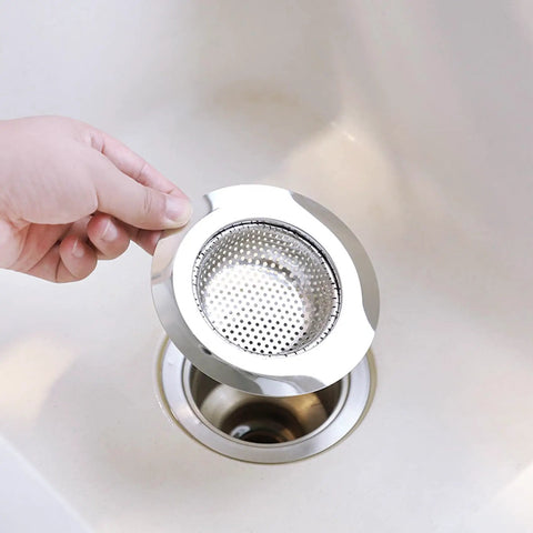 Real Heavy Hitter Stainless Steel Tub Drain Strainer And Shower Hair Catcher held above a sink, showing its design for hair trapping.