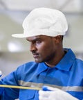Anti Static Mesh Work Cap Keeps Your Crown Clean And Airy On The Floor Dust Resistant Beard Net For Food Plants Electronics Shops And Cleanrooms, worn by a worker measuring in a blue shirt.