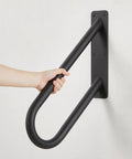 Built Tough Heavy Duty Metal Handrails U Shaped Safety Grab Bars Featuring Non Slip Black Powder Coating For Rugged Wall Mount Outdoor Indoor Stairs Porch Access, close-up with hand gripping bar.