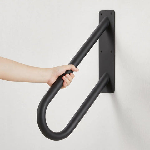 Built Tough Heavy Duty Metal Handrails U Shaped Safety Grab Bars Featuring Non Slip Black Powder Coating For Rugged Wall Mount Outdoor Indoor Stairs Porch Access, close-up with hand gripping bar.