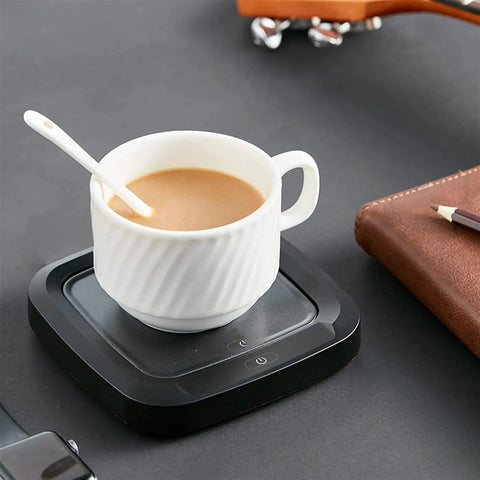 Keep Your Daily Brew Piping Hot With This Smooth Operator Ceramic Coffee Mug Warmer Featuring Fast Ptc Heating Non Slip Base And No Mess Setup Built For Office Or Couch Sweet Sips Always. White ceramic mug on black coffee warmer.
