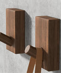 Modern Wall Mounted Coat Rack With Smooth Beige Finish Sleek Space Saving Design For Entryways with two hooks holding a strap.