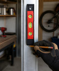 Spirit Level, New Yellow Level 23CM attached to metal while a gloved hand marks alignment in a workspace.