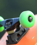 Close-up of a skateboard wheel and truck featuring a skateboard truck hardware kit with 8 spacers 8 axle nuts and 40 speed rings for skateboards.