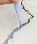 Premium Strength Concrete Crack Repair Adhesive And Quick Drying Waterproof Sealant For Driveway Patio Walkways Solid Fix Tough As Nails Outdoor Patch Gray Tube applied to fill a crack in the concrete.
