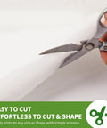 Person cutting half inch thick polyester batting with scissors for DIY couch and furniture repair, 36 by 9 feet roll.