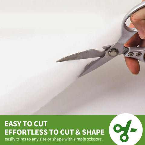 Person cutting half inch thick polyester batting with scissors for DIY couch and furniture repair, 36 by 9 feet roll.