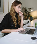 Woman working at desk with 2 Pack Desk Grommet 2 Inch 50 Mm Hole Cover For Cables Black Desk Cord Hole Cover visible on table