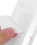 Hand peeling off adhesive backing from Top Shelf Under Desk Laptop Mount Clear Acrylic Wall Bracket for Universal Tablets.