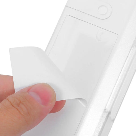 Hand peeling off adhesive backing from Top Shelf Under Desk Laptop Mount Clear Acrylic Wall Bracket for Universal Tablets.