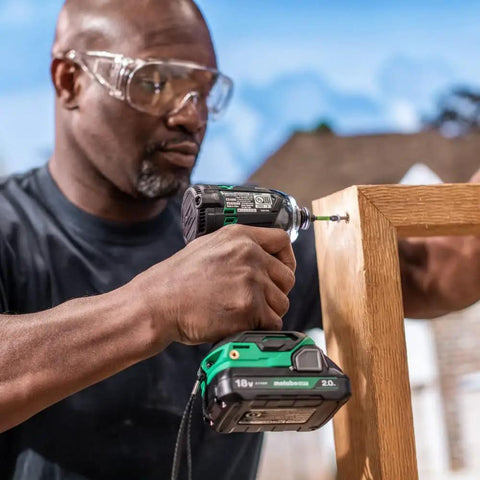 Person using 18V MultiVolt Cordless Triple Hammer BOLT Impact Driver Tool Only - 1/4-Inch Hex on wooden frame outdoors