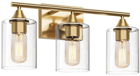 Brushed brass three light vanity light fixture with clear glass shades, ideal for bathroom mirror or kitchen use.