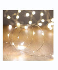 Battery Operated Fairy String Lights 10 Ft Copper Wire With 30 Micro LEDs Waterproof Indoor Outdoor Decor glowing on wood.